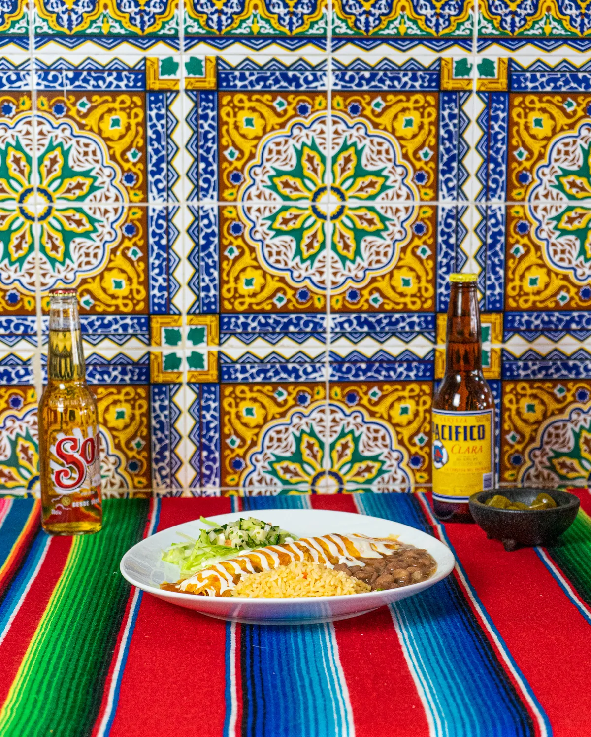 Pared de azulejos de talavera con cervezas y un plato